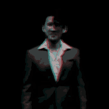 a man in a suit is standing in the dark