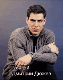 a man wearing a grey sweater has the date 09.07.078 on the bottom right