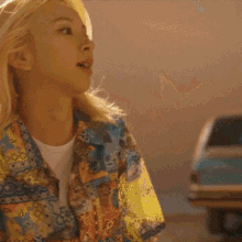 a woman wearing a colorful shirt with a white shirt underneath it