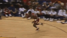 a man is jumping in the air on a basketball court with a sign that says ' boston ' on it