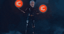 a man stands in front of two circles with the letter c in them