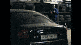 a black car with smoke coming out of the back and a license plate that says hbt14w62