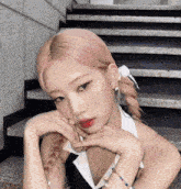 a woman with pink hair is posing for a picture in front of some stairs