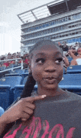 a woman sitting in a stadium with a shirt that says ' apollo ' on it