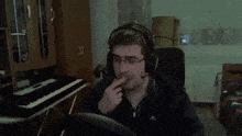 a man wearing headphones is sitting in front of a piano