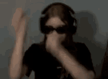 a girl wearing headphones and sunglasses is sitting with her arms crossed