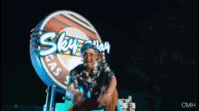 a man with blue hair stands in front of a sign that says sky gas station