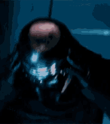 a close up of a man 's face in a dark room with a blurred background .