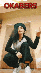 a woman squatting down with the word okabers on the bottom