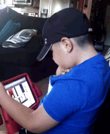 a boy in a blue shirt is using a tablet