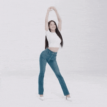 a woman in a white shirt and blue jeans dancing