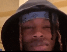 a close up of a person wearing a hat and a bandana .