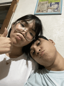 a man and a woman are posing for a picture and the man is giving the woman a thumbs up