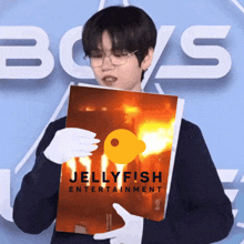 a person holding a book that says jellyfish entertainment on it