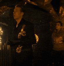 a man in a black suit holds a trophy