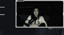 a woman wearing headphones and a gap sweater is sitting in front of a microphone