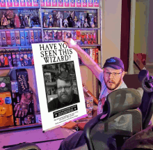 a man is holding a poster that says have you seen this wizard