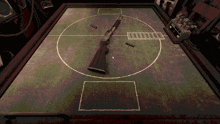 a shotgun is laying on a table with a scoreboard in the background that shows the score as a tie