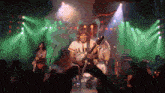 a man playing a guitar wearing a shirt that says ' aa ' on it