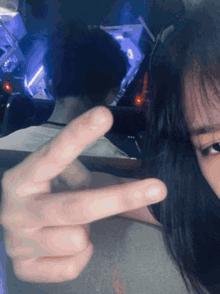 a woman is making a peace sign with her hands