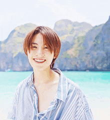 a young man in a striped shirt smiles for the camera