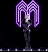 two anime characters are dancing in front of a glowing m symbol