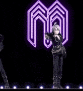 a couple of anime characters dancing in front of a glowing letter m