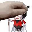 a cartoon character in a red and black outfit is holding a cane while a hand holds a blanket over him .
