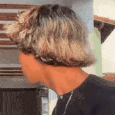 a man with short blonde hair is wearing a black shirt .