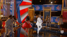 a group of people dancing on a stage with the words voz en vivo on the bottom right