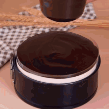 a chocolate cake is being poured into a plastic container