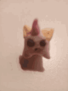 a close up of a stuffed animal with a unicorn horn on a white background .
