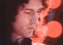 a close up of a man 's face with his eyes closed in front of a blurry background .
