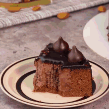 a piece of chocolate cake on a plate with a kiss on top