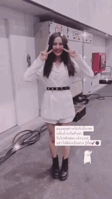 a woman in a white jacket and shorts is standing in a room with a sign that says ' a '