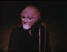 a man wearing a mask singing into a microphone
