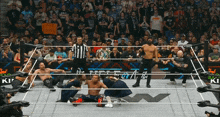 wrestlers in a wrestling ring with a referee and a sign that says " i 'm a fan "