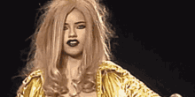 a woman in a wig is holding a microphone and wearing a gold jacket .