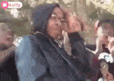 a group of people are sitting in a car and one of them is wearing a hoodie .