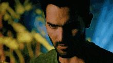 a close up of a man 's face with a beard in a dark room .