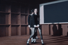 a group of women are dancing in a dark room with their hands up
