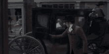a man in a top hat stands next to a carriage
