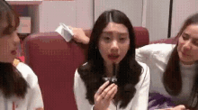 a group of young women are sitting on a red couch .