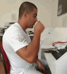a man wearing a white shirt with a patch that says ' chicago ' on it is sitting at a desk