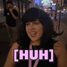 a woman wearing a wig and a lanyard that says ' [ huh ] ' on it