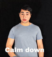 a man in a blue shirt says calm down in white letters