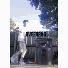 a man is standing in front of a trash can with the words loveforkg on the bottom