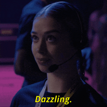 a woman wearing a headset and a lanyard that says ' dazzling '