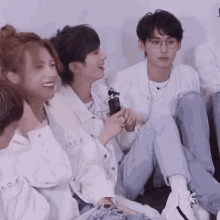 a group of young people are sitting on the floor laughing and talking .