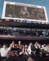 a crowd of people are gathered in front of a big screen that says mississippi state